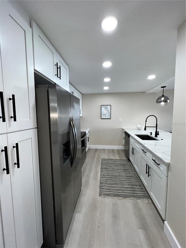 kitchen featuring light hardwood / wood-style floors, white cabinetry, sink, and appliances with stainless steel finishes