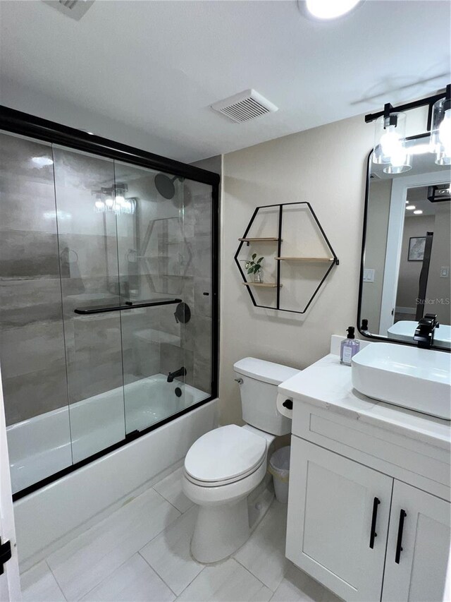 full bathroom with tile patterned floors, vanity, toilet, and combined bath / shower with glass door