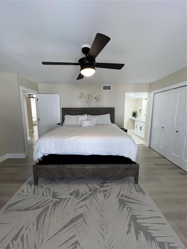 bedroom with wood-type flooring, a closet, and ceiling fan