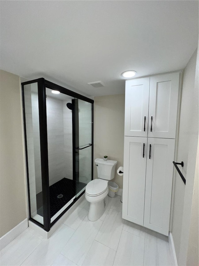 bathroom with tile patterned floors, toilet, and an enclosed shower