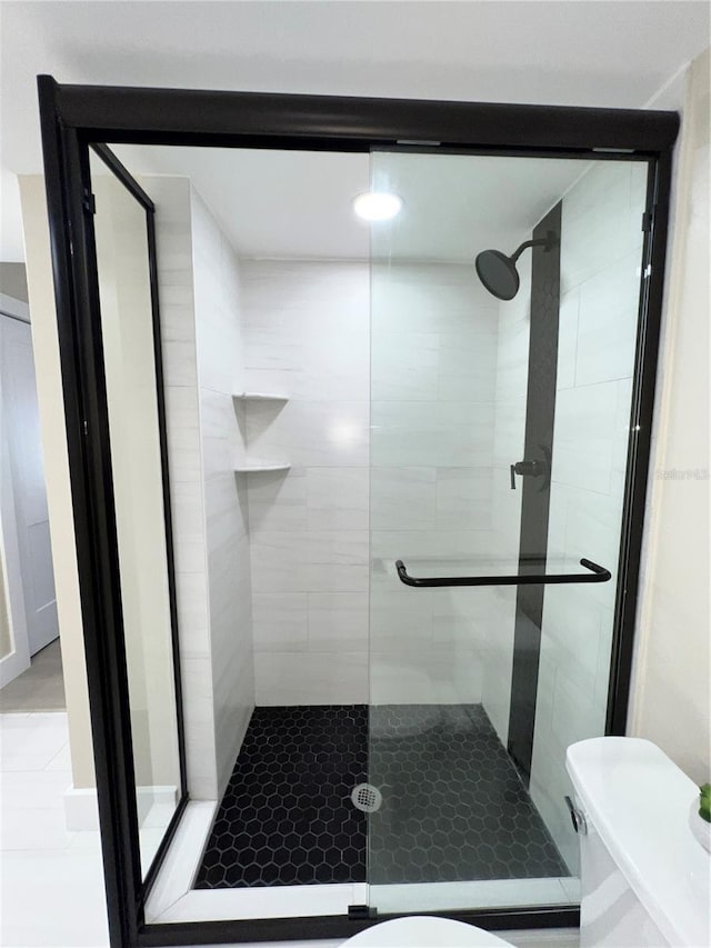 bathroom with tile patterned flooring, toilet, and walk in shower