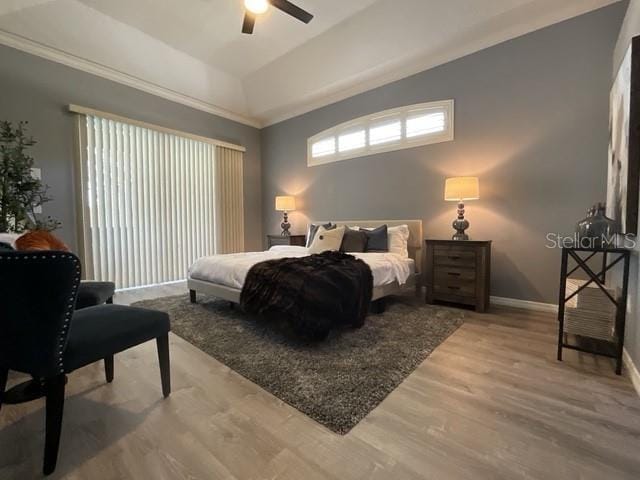 bedroom with baseboards, wood finished floors, a ceiling fan, and lofted ceiling