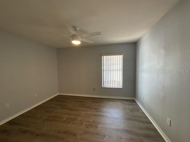 spare room with ceiling fan, wood finished floors, and baseboards