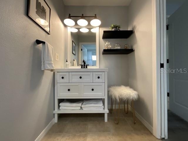 bathroom featuring tile patterned floors, vanity, and baseboards