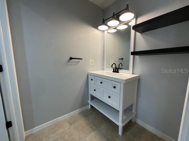 bathroom with baseboards, tile patterned floors, and vanity