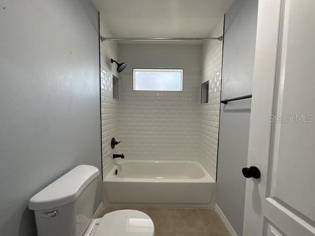 bathroom with toilet, tile patterned flooring, shower / bathtub combination, and baseboards
