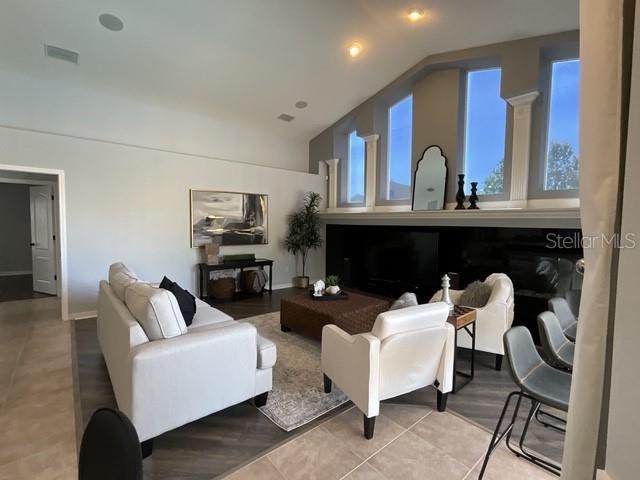 living area with lofted ceiling and visible vents