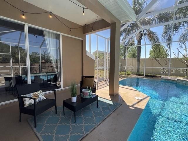 view of pool featuring fence, a fenced in pool, glass enclosure, and a patio area