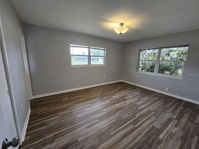 empty room featuring dark hardwood / wood-style flooring and a textured ceiling