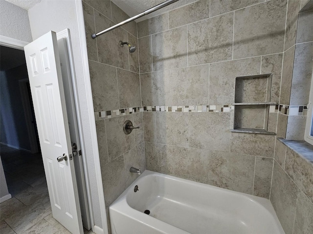 bathroom featuring a textured ceiling, tiled shower / bath combo, and tile patterned floors