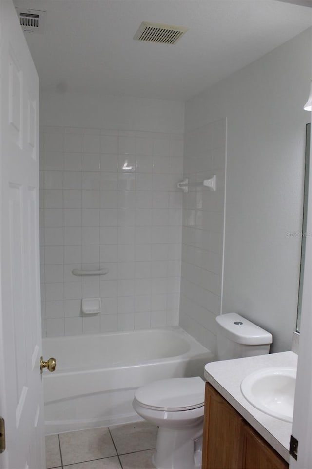 full bathroom with tile patterned floors, tiled shower / bath, vanity, and toilet