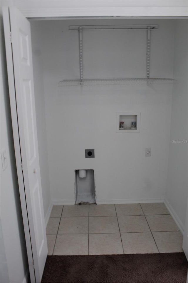 washroom with hookup for an electric dryer, light tile patterned floors, and hookup for a washing machine