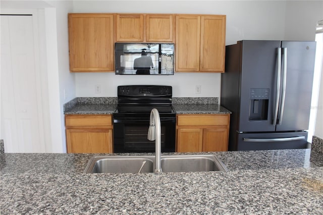 kitchen with black appliances, dark stone countertops, and sink