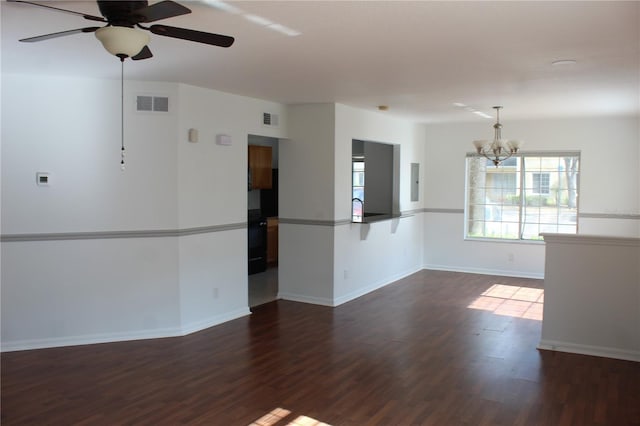 empty room with ceiling fan with notable chandelier, dark wood-type flooring, and electric panel