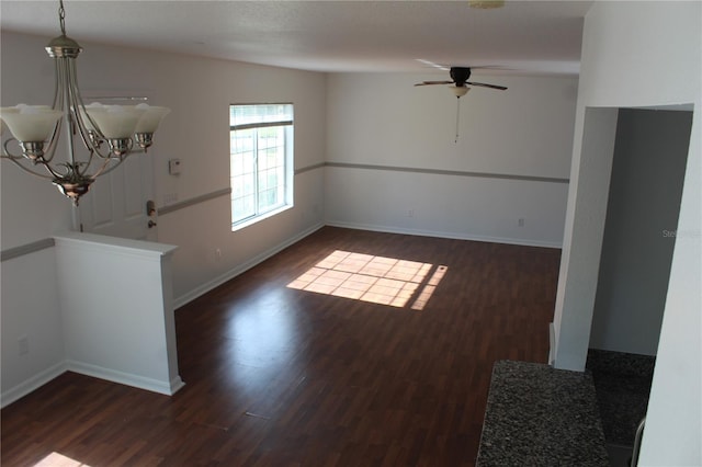 interior space featuring ceiling fan with notable chandelier and dark wood-type flooring