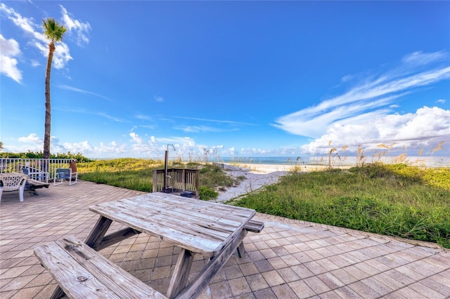 view of patio / terrace with a water view and a view of the beach