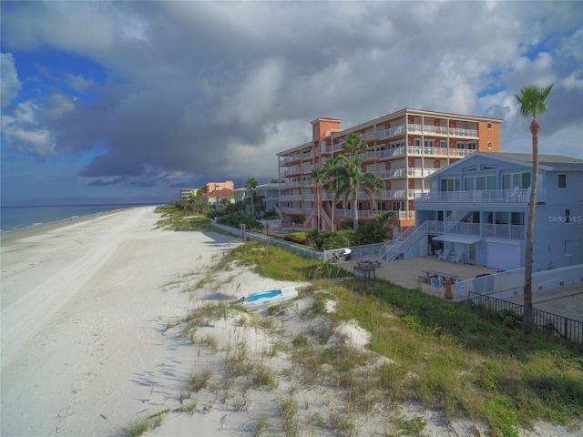 view of building exterior featuring a beach view and a water view