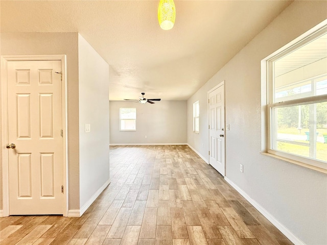 foyer with baseboards, light wood-type flooring, and a ceiling fan