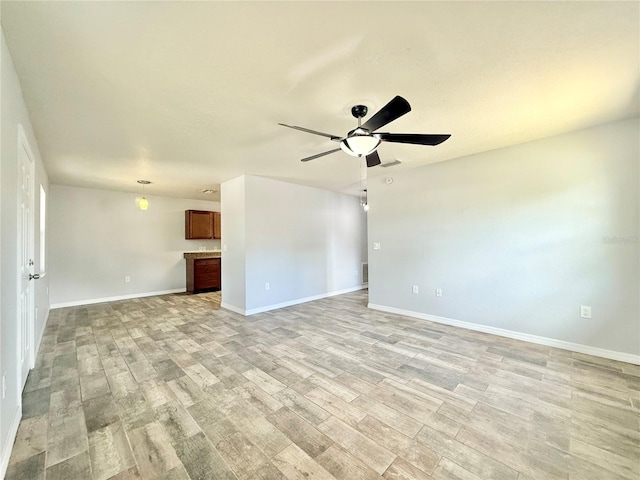 unfurnished room featuring ceiling fan, light wood finished floors, and baseboards