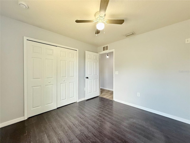 unfurnished bedroom featuring dark wood-style flooring, baseboards, and visible vents