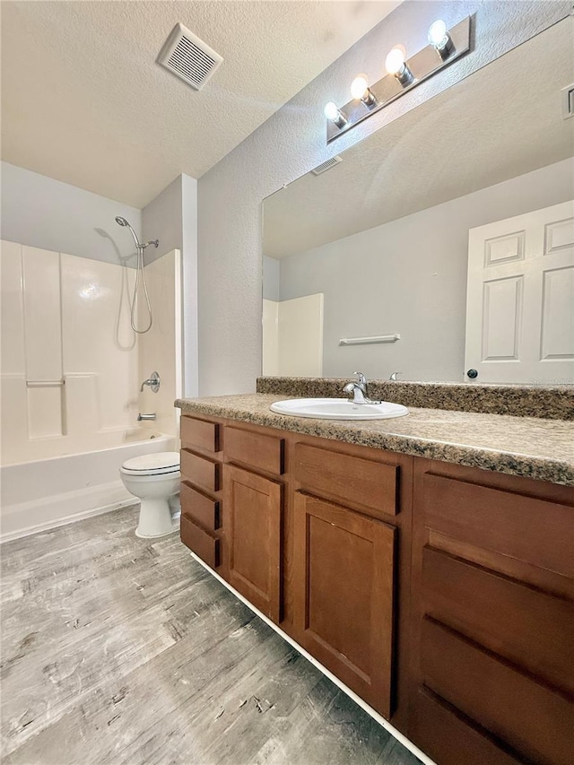 bathroom with visible vents, toilet, bathtub / shower combination, vanity, and wood finished floors