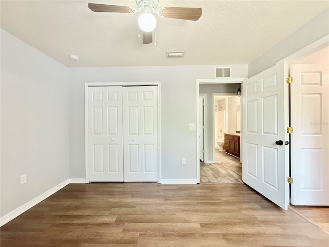 unfurnished bedroom featuring a closet, visible vents, baseboards, and light wood-style flooring