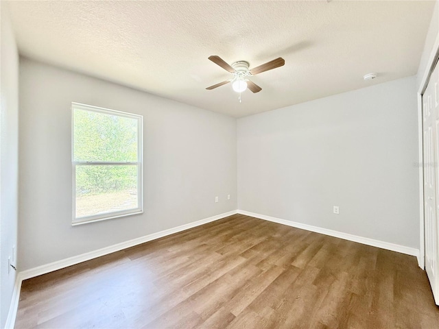 unfurnished room featuring ceiling fan, wood finished floors, and baseboards