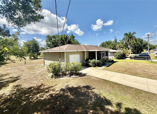 view of front of home with an attached garage, driveway, and a front lawn