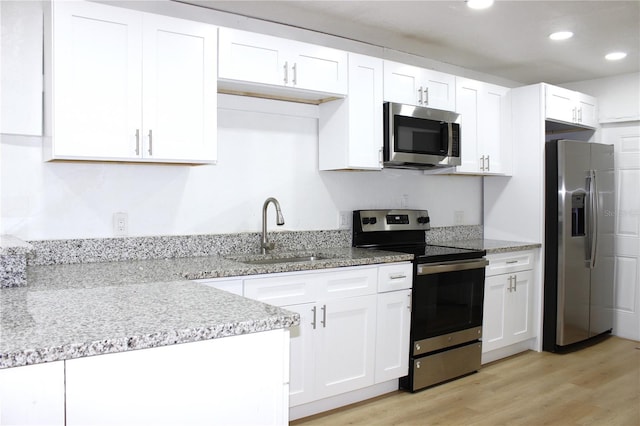 kitchen with white cabinets, sink, light wood-type flooring, and stainless steel appliances