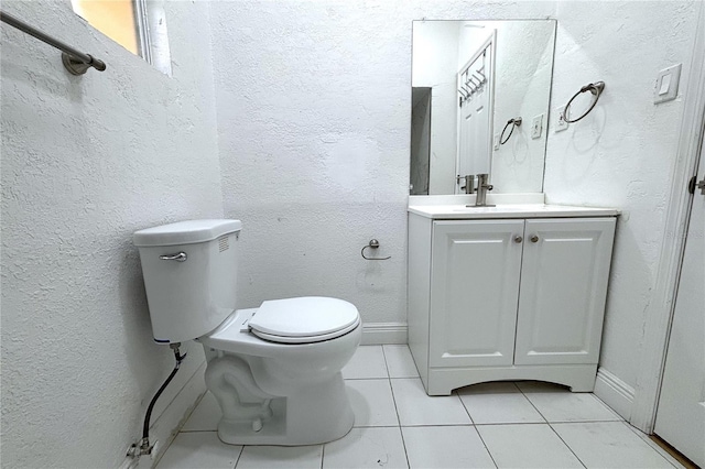 bathroom with tile patterned flooring, vanity, and toilet