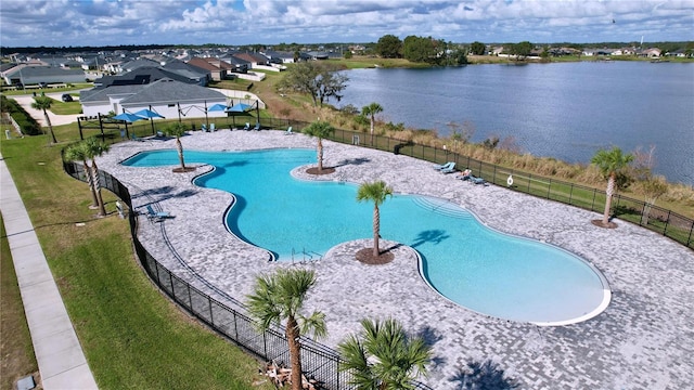 view of swimming pool with a water view and a lawn