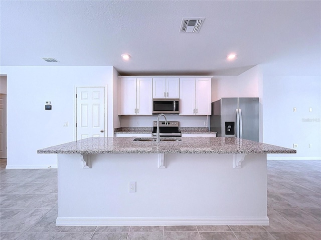 kitchen featuring white cabinetry, a kitchen island with sink, sink, and stainless steel appliances