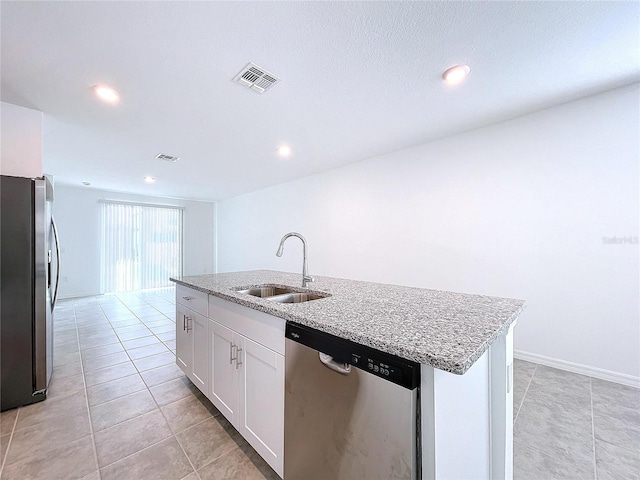 kitchen with a center island with sink, sink, light stone countertops, white cabinetry, and stainless steel appliances