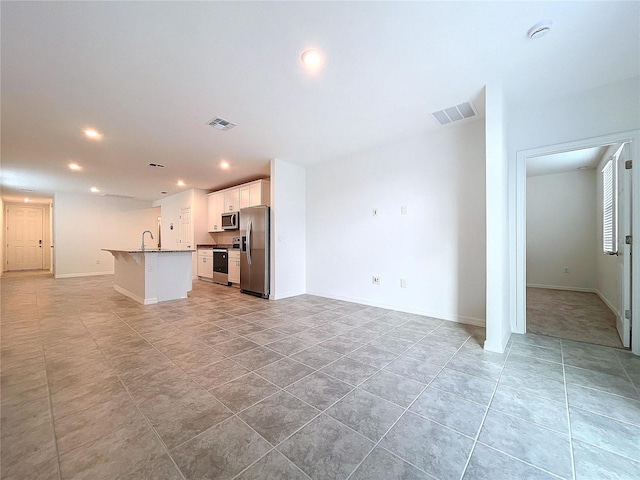 unfurnished living room with light tile patterned floors and sink