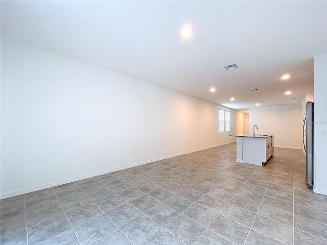 spare room featuring sink and light tile patterned floors