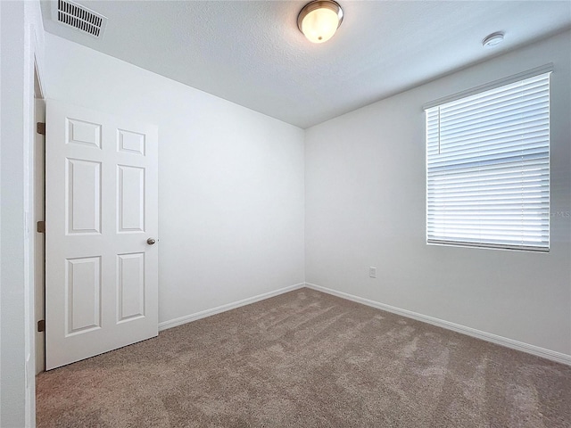 carpeted spare room with a textured ceiling