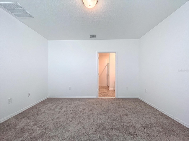 carpeted empty room with a textured ceiling