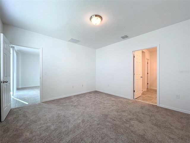 carpeted spare room featuring a textured ceiling