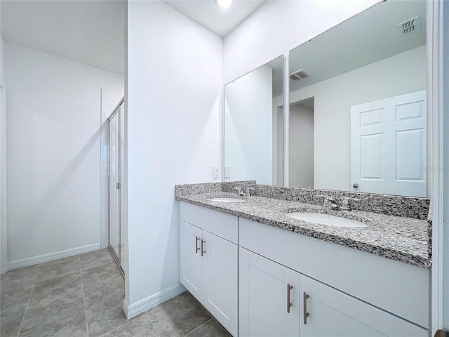 bathroom with tile patterned flooring, vanity, and a shower with shower door