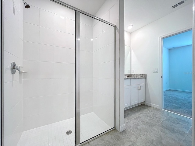 bathroom with tile patterned flooring, vanity, and a shower with shower door