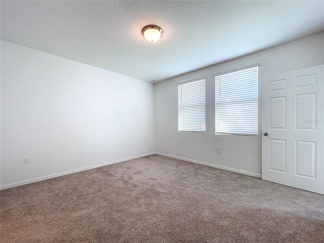 unfurnished room featuring carpet and a textured ceiling