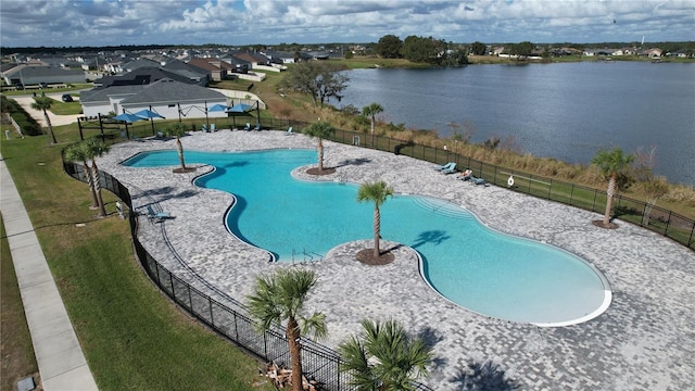 view of pool with a water view and a lawn