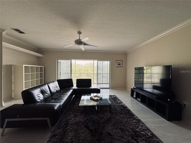 living room with a textured ceiling, ceiling fan, and crown molding