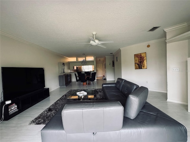 living room featuring a textured ceiling, ceiling fan, and crown molding