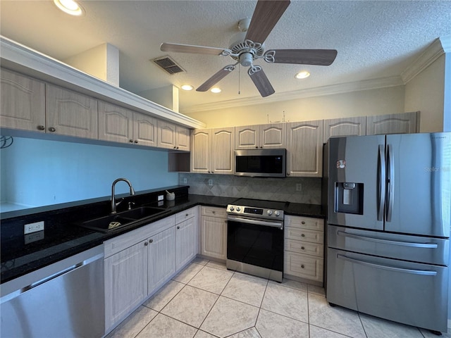 kitchen featuring stainless steel appliances, light tile patterned floors, a textured ceiling, decorative backsplash, and sink