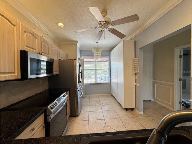 kitchen with appliances with stainless steel finishes, crown molding, light tile patterned floors, light brown cabinetry, and a textured ceiling