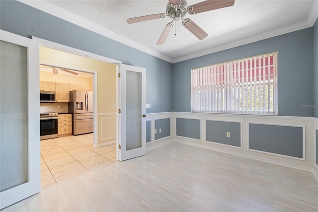 tiled empty room featuring crown molding, ceiling fan, and a textured ceiling