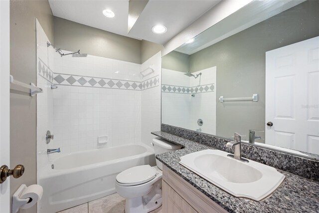 full bathroom featuring vanity, tiled shower / bath, tile patterned flooring, and toilet