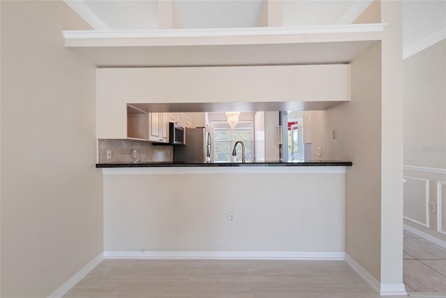 kitchen featuring stainless steel appliances, sink, dark stone countertops, and decorative backsplash