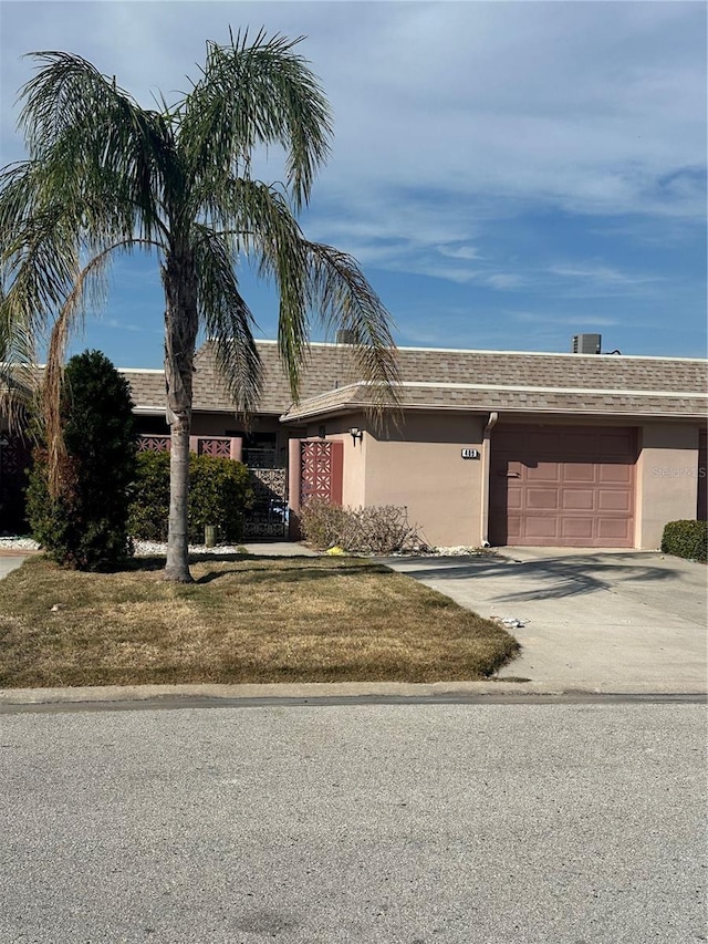 single story home with a garage and a front lawn